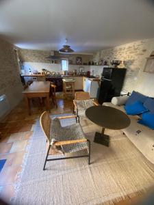 a living room with a table and chairs and a kitchen at La malle bleue in Vallabrix