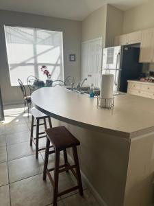 a kitchen with a large island in a kitchen with chairs at Magical Home with private pool and close to parks in Kissimmee