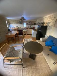 Una sala de estar con mesa y sillas y una cocina. en La malle bleue, en Vallabrix 14 fotos más