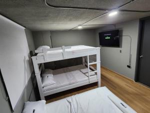 a small room with a bunk bed and a tv at Eureka Living in Bucaramanga