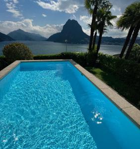 una piscina azul con vistas al agua en Attico con vista panoramica sul lago - due camere, en Lugano