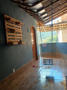 an empty room with a wooden floor and a swing at House available for the Rock the Mountain event in Petrópolis