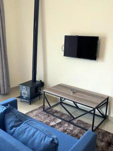 a living room with a couch and a table and a stove at Chalet 101 - Zresidence - Faitroun in Al ‘Aqabah +3 photos