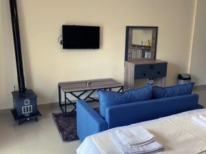 a living room with a blue couch and a tv at Chalet 101 - Zresidence - Faitroun in Al ‘Aqabah