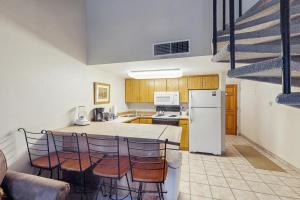 a kitchen with a table and chairs and a refrigerator at Summit House East 112 in Copper Mountain