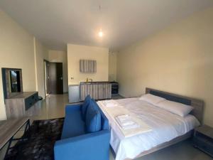 a bedroom with a large bed and a blue couch at Chalet 101 - Zresidence - Faitroun in Al ‘Aqabah