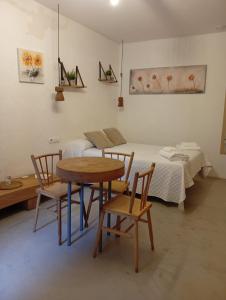 a room with a bed and a table and chairs at Ánimas, elegantes pisos en el centro histórico in Pontevedra