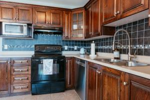 セントジョンズにあるSt Johns Retreat Terrace 3 BR & 2 Bathsのキッチン(木製キャビネット、コンロ、シンク付)