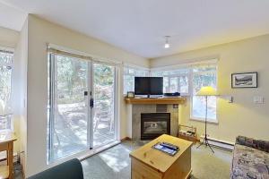 a living room with a fireplace and a tv at The Lagoons 27 in Whistler