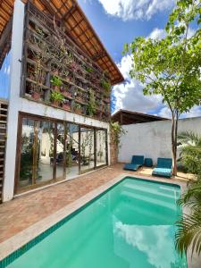 einem Pool vor einem Haus mit einem Gebäude in der Unterkunft Casa do Sol in São Miguel do Gostoso