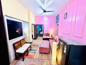 a living room with pink walls and a couch at The Family Courtyard, 5 Bed Room Boutique Villa and Guest Inn in Lucknow +49 photos