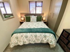 a bedroom with a large bed with green pillows at Modern Van Riebeeck Park Accomodation in Worcester