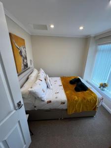 a bedroom with a bed with a yellow blanket on it at Angel Cottage, Strone in Dunoon +15 photos