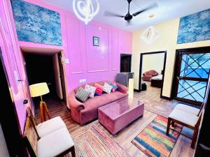 a living room with pink walls and a couch at The Family Courtyard, 5 Bed Room Boutique Villa and Guest Inn in Lucknow