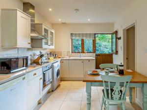 cocina con mesa y microondas en 1 Bed in Bampton 94766, en Bampton