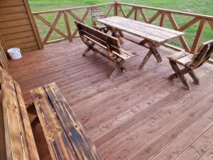 a wooden deck with a picnic table and a bench at Domek u Stasia in Połęczyno