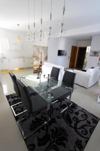 a dining room with a glass table and black chairs at Marble Arch in St Julian's +11 photos