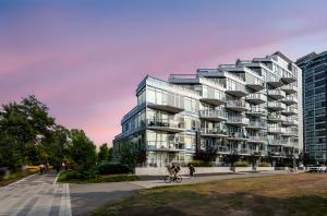 a rendering of a building with people bicycling in front of it at Parkside at Waterfront in Downtown Calgary in Calgary
