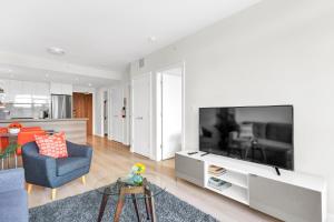 a living room with a large flat screen tv at Parkside at Waterfront in Downtown Calgary in Calgary +26 photos