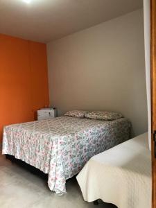 2 camas en una habitación pequeña con paredes de color naranja en Alphaville Pousada e Hostel, en Bonito