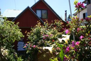a red house with flowers in front of it at Newendo Pucón in Pucón
