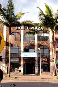 a hotel with palm trees in front of a building at Hotel Plaza El Santuario in Santuario