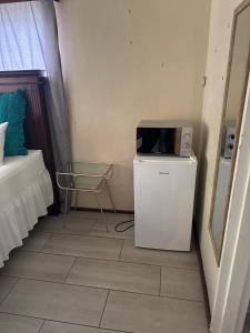 a room with a microwave on top of a refrigerator at Eagles Enest BnB in Pietermaritzburg +49 photos