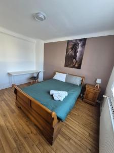 a bedroom with a bed with a green comforter at La parenthèse, appartement avec balcon in Châteaudun