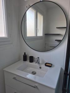 a bathroom with a white sink and a mirror at La parenthèse, appartement avec balcon in Châteaudun +13 photos
