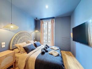 a bedroom with a large bed with a large tv on the wall at Appart City break Chic Cosy Wifi Caen Hyper centre in Caen