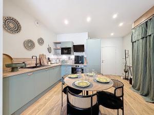 a kitchen with a table and chairs in a room at Appart City break Chic Cosy Wifi Caen Hyper centre in Caen +4 photos
