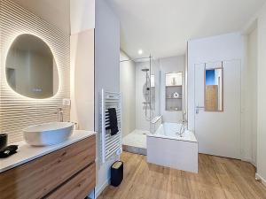 a white bathroom with a sink and a tub at Appart City break Chic Cosy Wifi Caen Hyper centre in Caen