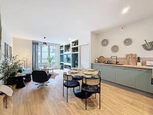 a kitchen and living room with a table and chairs at Appart City break Chic Cosy Wifi Caen Hyper centre in Caen