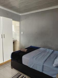 a bedroom with a bed and a bathroom at Just Bed&Bath by Mama R in Newcastle
