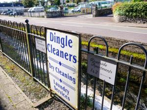 ディングルにあるRiverside Dingle - Luxury Apt 2の道路脇のフェンスに立てられたたくさんの看板