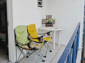 a room with a table and a chair and a table at Suite Bouganville in Matinhos