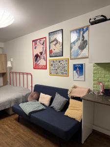 グダウリにあるGudauri Loft Apartment 416のリビングルーム(青いソファ、壁にポスター付)