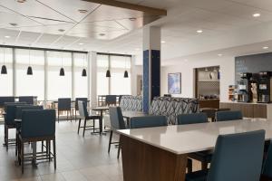 a dining room with chairs and tables and windows at Holiday Inn Express & Suites Meridian I-20 by IHG in Meridian