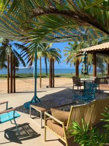 a patio with chairs and umbrellas on the beach at Itacimirim Beach House in Camacari