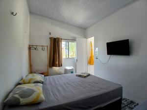 a bedroom with a bed and a flat screen tv at Pousada Unidos in Jijoca de Jericoacoara +47 photos