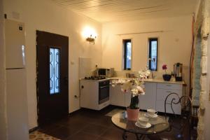 - une cuisine avec une table et des fleurs dans l'établissement Villa Corin, à Gornot HaGalil