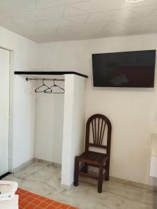 una silla en una habitación con TV en la pared en Palacio de los Angeles, en San Felipe Hueyotlipan