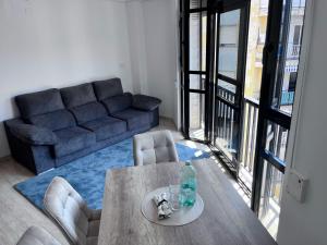 a living room with a table and a couch at Casa Blanca - apartamento en Gandia in Gandía