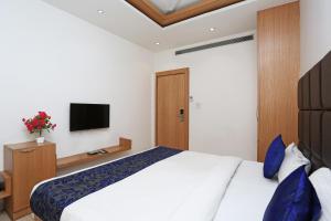 a bedroom with a bed and a tv on the wall at Collection O Sun Park in Bhopal