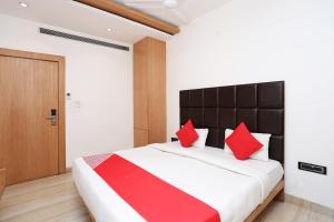 a bedroom with a large bed with red pillows at Collection O Sun Park in Bhopal
