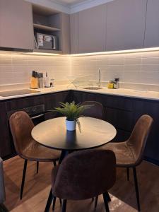 a kitchen with a table and chairs and a sink at HOM I Lujoso Depto 2D2B, Ñuñoa con Estacionamiento in Santiago