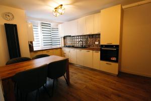 een keuken met een tafel en stoelen en een klok bij DaVinci Apartment with Self Check-In in Târgu-Mureş