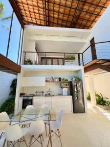 eine Küche und ein Esszimmer mit einem Glastisch und Stühlen in der Unterkunft Casa do Sol in São Miguel do Gostoso + 68 Fotos