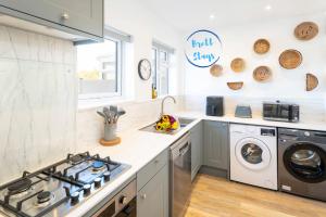 a kitchen with a stove and a washing machine at Contractor Accommodation Avonmouth 3 Bedroom House Sleeps 6 Free Van Parking in Avonmouth