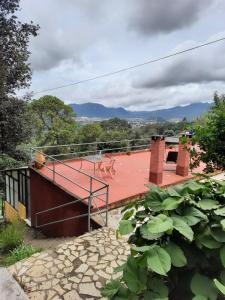 a house with a red deck with a statue on it at Cabañas la garita2 in San Cristóbal de Las Casas